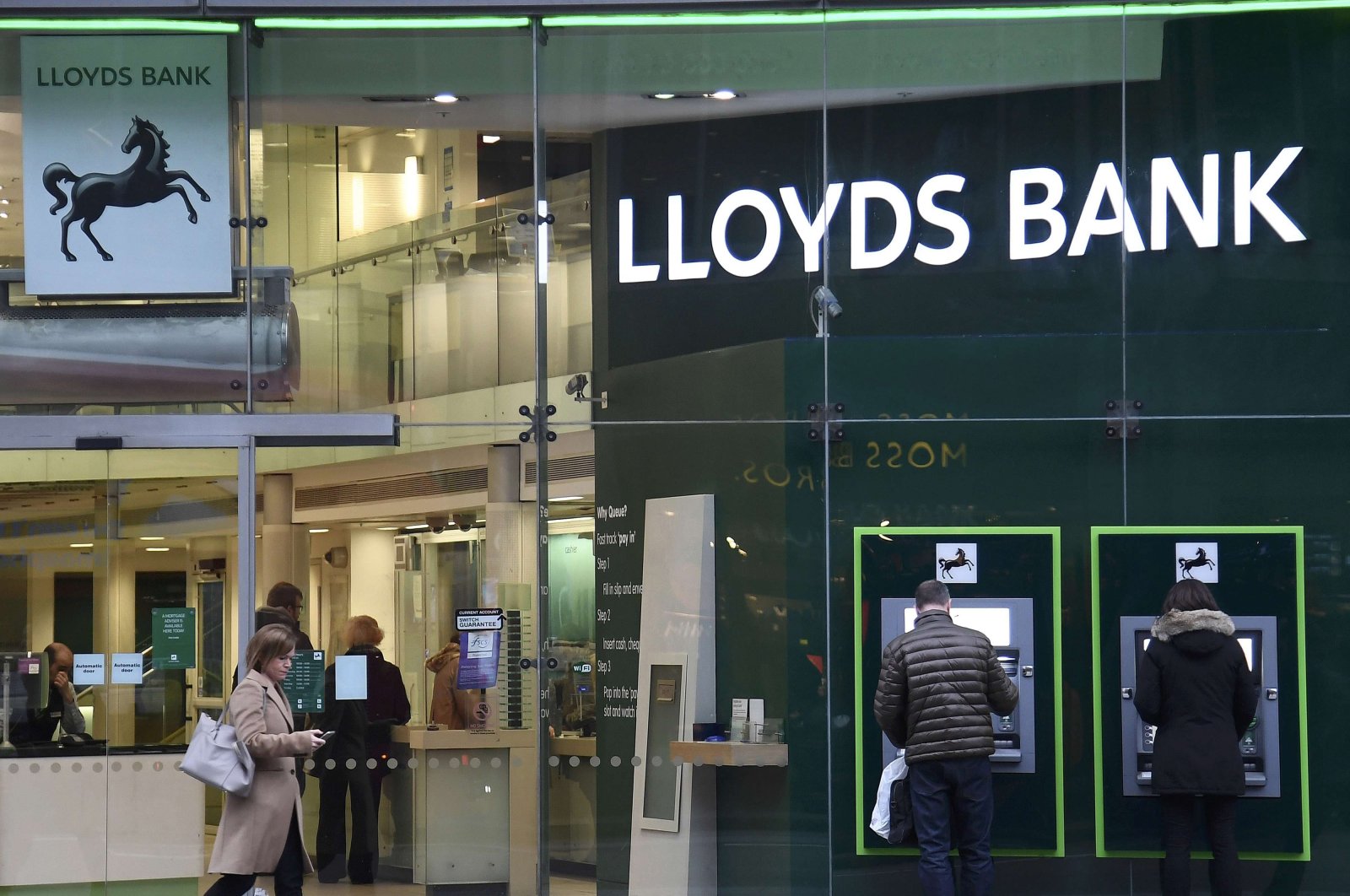 Customers use ATMs at a branch of Lloyds Bank in London, Feb. 21, 2017. (Reuters Photo)