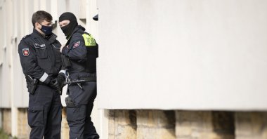 Police officers are standing outside an apartment building during a search in Osnabruck, Germany, Nov. 6, 2020. (AP Photo)
