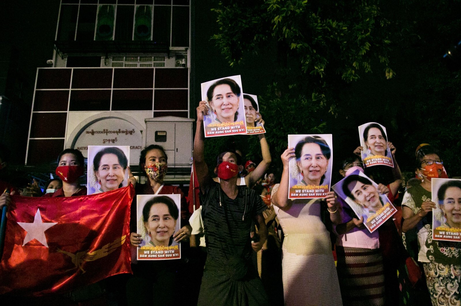 Supporters of the National League for Democracy (NLD) party hold portraits of Aung San Suu Kyi as they celebrate the unofficial election results in front of the party's headquarters in Yangon, Myanmar, Nov. 9, 2020. (AFP Photo)