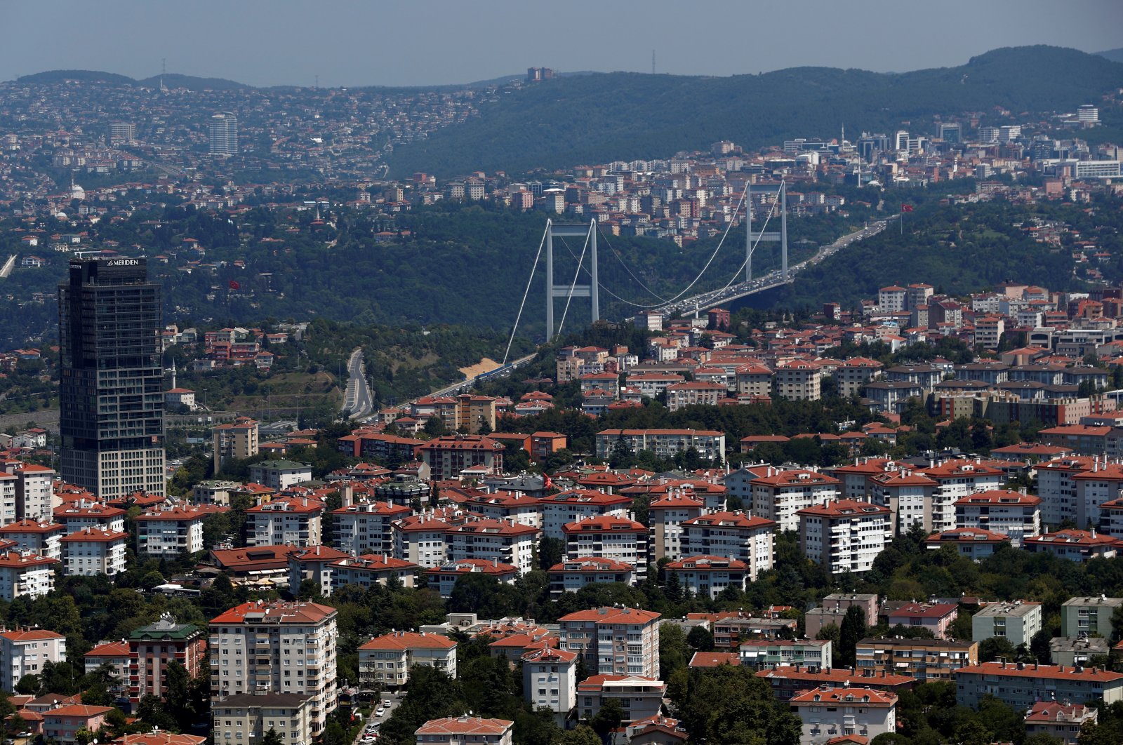 The Fatih Sultan Mehmet Bridge linking the city's European and Asian side over the Bosporus rises behind residential apartment blocks in Istanbul, Turkey, Aug. 1, 2019. (Reuters Photo)