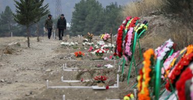 Men walk along graves of soldiers and civilians who were killed during clashes over Nagorno-Karabakh, in Stepanakert, Nov. 2, 2020. (Reuters Photo)