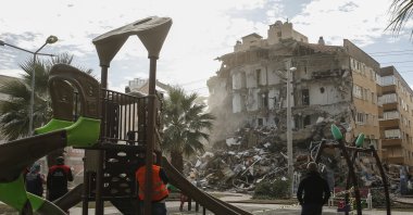 People inspect the debris of a collapsed building from a nearby playground after the earthquake in Izmir, Turkey, Nov. 2, 2020. (AP Photo)