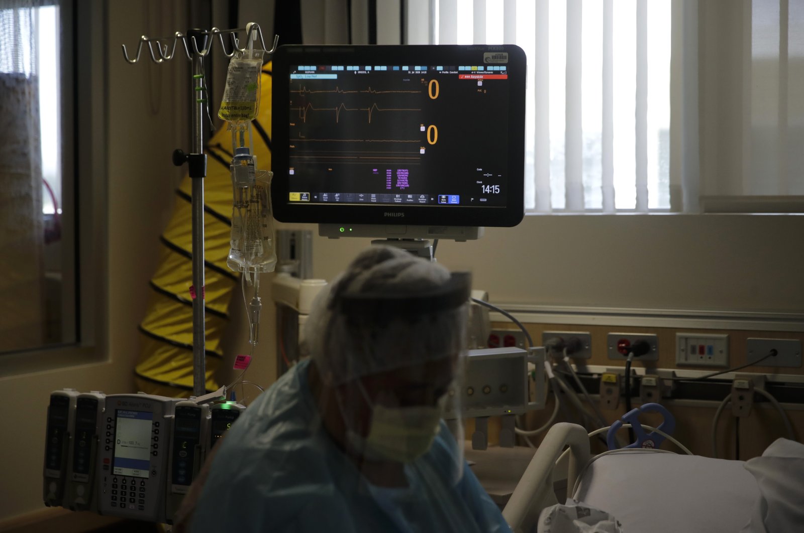 A woman sobs while sitting at the bedside of her dying husband as his heart rate drops to zero in a COVID-19 unit at St. Jude Medical Center in Fullerton, Calif., Friday, July 31, 2020. (AP Photo)