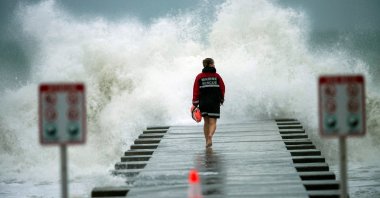 A lifeguard walks to the end of the jetty after closing it down to surfers before the arrival of Tropical Storm Eta in Bradenton Beach, Florida, U.S., Nov. 11, 2020. (Reuters Photo)