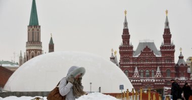 A woman walks in front of a huge temporary dome covering the mausoleum of Soviet state founder Vladimir Lenin at the Red Square in Moscow, on March 25, 2013. (AFP Photo)