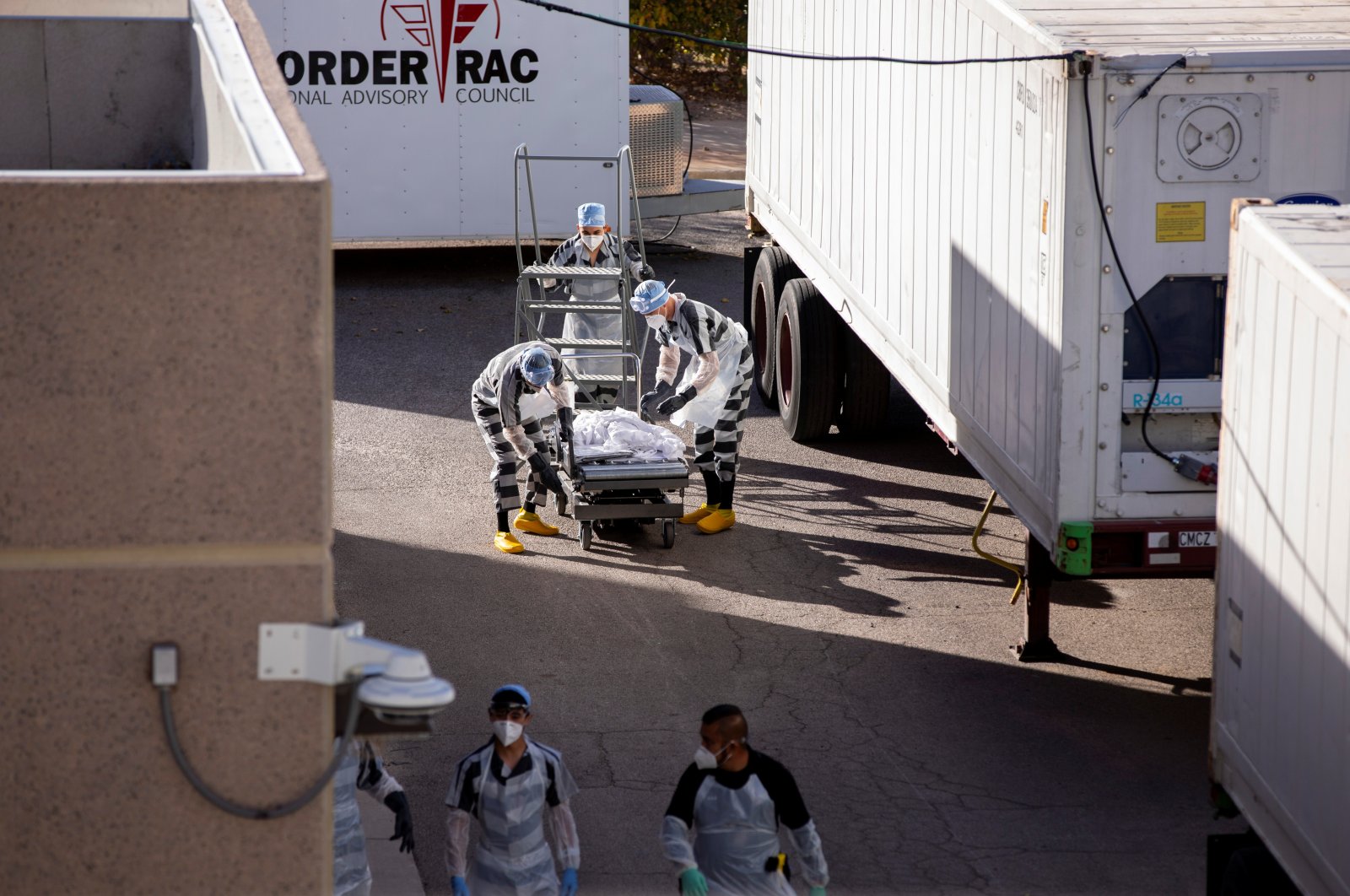 El Paso County detention inmates, also known as trustees (low-security inmates) help move bodies to refrigerated trailers deployed during a surge of COVID-19 deaths, outside the Medical Examiner's Office in El Paso, Texas, U.S. Nov. 14, 2020.  (Reuters Photo)
