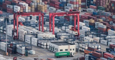 A cargo truck drives between stacked shipping containers at the Yangshan Port in Shanghai, China, March 29, 2018. (AP Photo)
