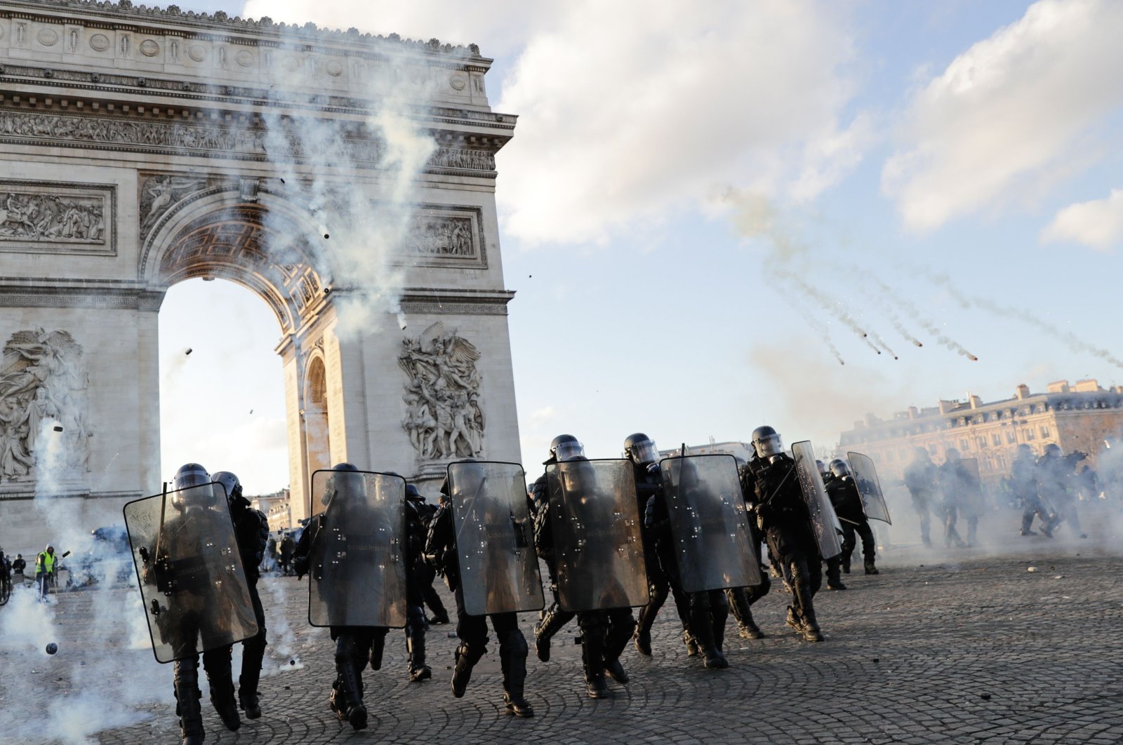 Riot police officers charge using tear gas canister at the Arc de Triomphe on the Place de l'Etoile, Paris, March 16, 2019. (AFP Photo)