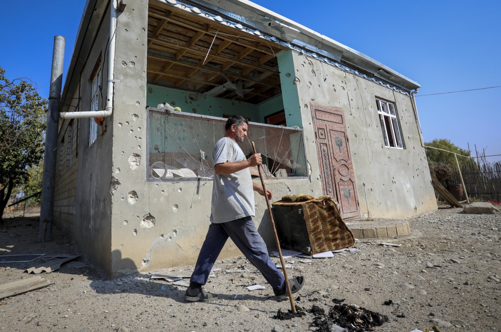 A man walks past a house damaged by shelling during fighting over the region of Nagorno-Karabakh in Aghdam, Azerbaijan, Oct. 19, 2020. (AP Photo)