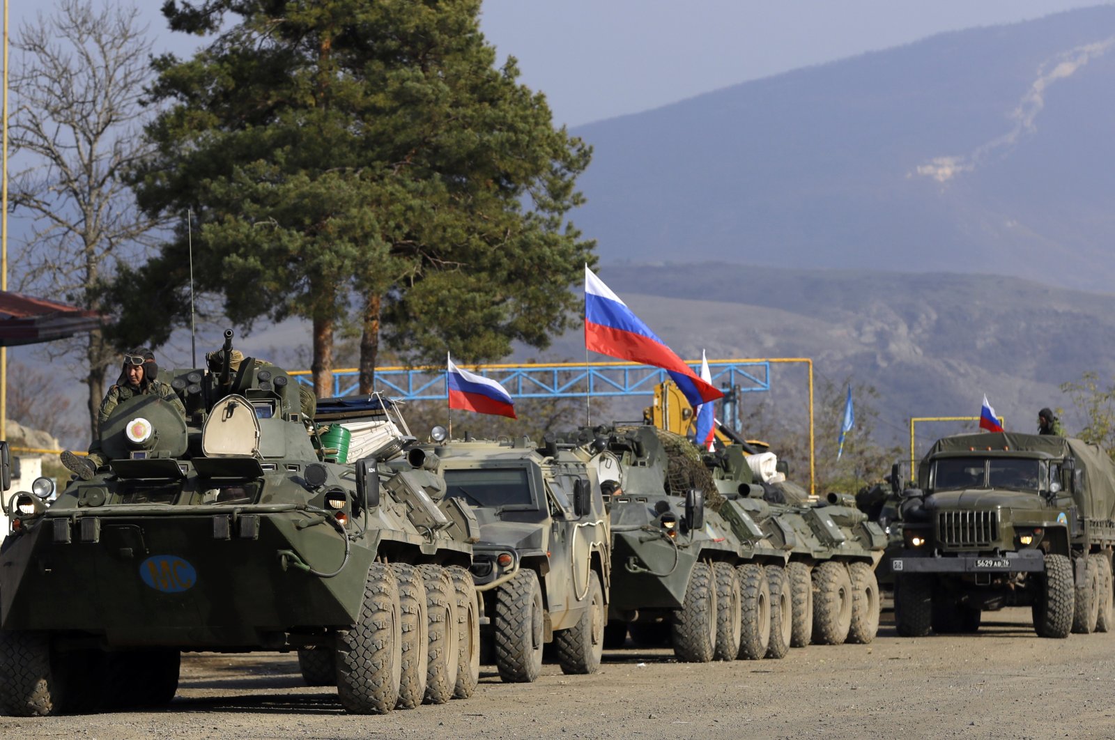 Russian peacekeepers' military vehicles with Russian national flags parked at a checkpoint on the road to Shusha in the region of Nagorno-Karabakh, Nov. 17, 2020. (AP Photo)