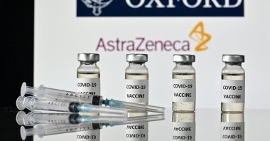 An illustration shows vials with COVID-19 vaccine stickers attached and syringes, under the logo of the University of Oxford and its partner, British pharmaceutical company AstraZeneca, Nov. 17, 2020. (AFP Photo)