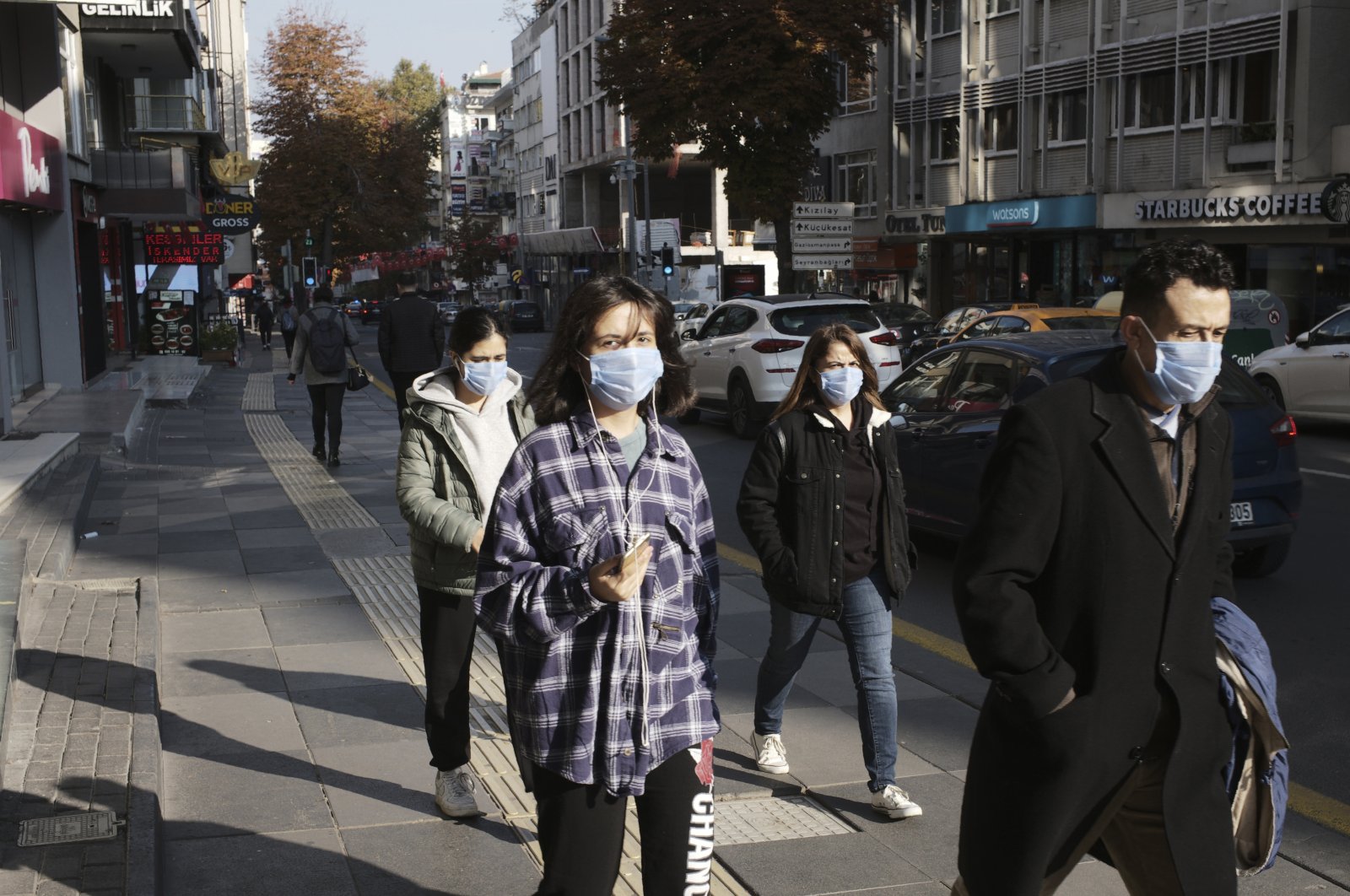People wearing masks to help protect against the spread of coronavirus, walk, in Ankara, Turkey, Monday, Nov. 15, 2020. (AP Photo)