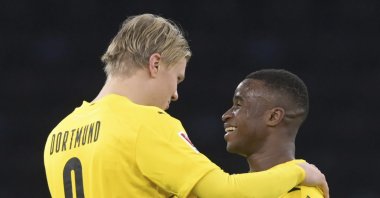 Dortmund's Erling Haaland (L) and Youssoufa Moukoko (R) hug each other after the match, in Berlin, Germany, Nov. 21, 2020. (AP Photo) 