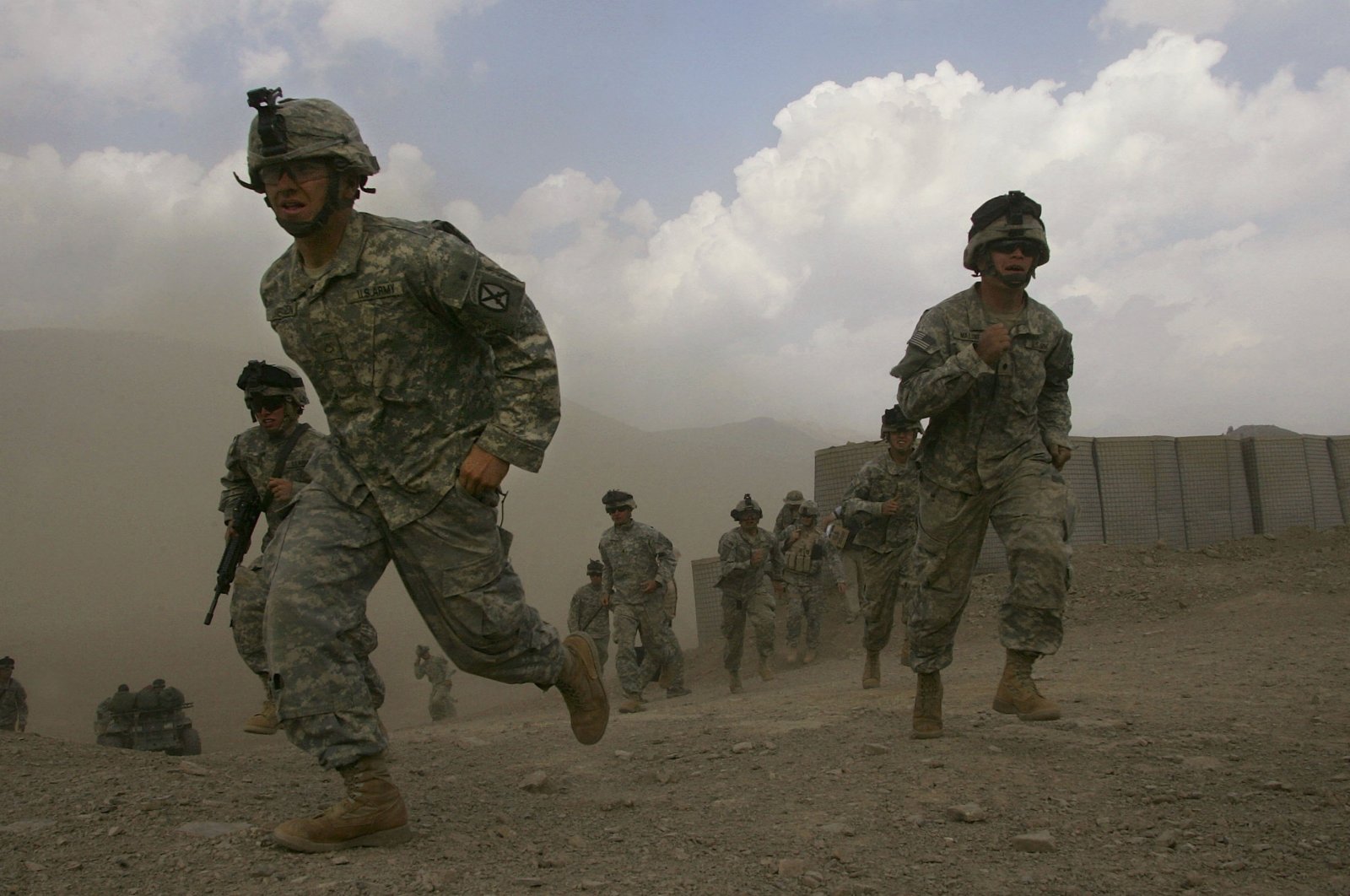 U.S. soldiers run to quickly unload a supply helicopter between Taliban rocket attacks, at Camp Tillman in the Paktika province of eastern Afghanistan, Oct. 24, 2006. (Photo by Getty Images)