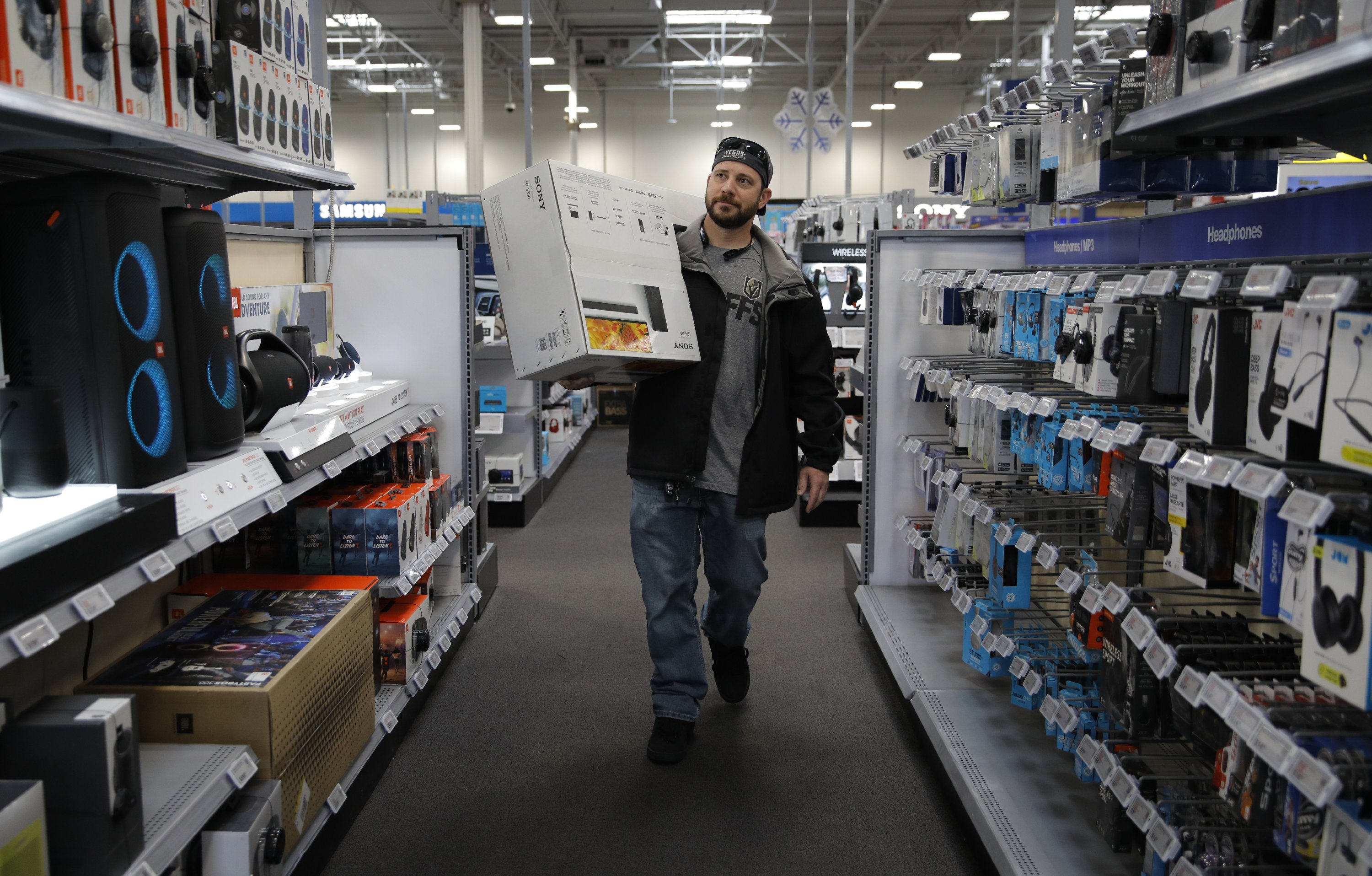 In this Nov. 26, 2019, file photo Nick Bierman carries an audio system while shopping ahead of Black Friday at a Best Buy in Henderson, Nev. (AP Photo)
