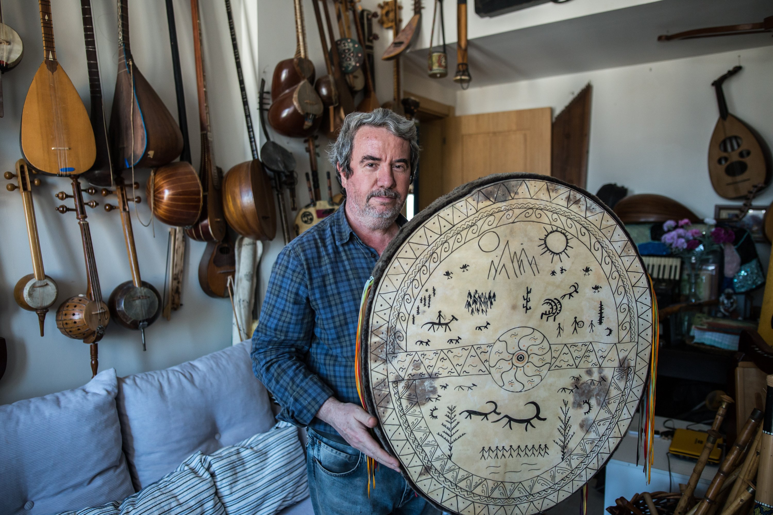 Feridun Obul poses with a Shaman drum that he made in his workshop in Sultanahmet Square, Istanbul, Turkey, Jan. 17, 2019. (PHOTO BY MURAT ŞENGÜL)