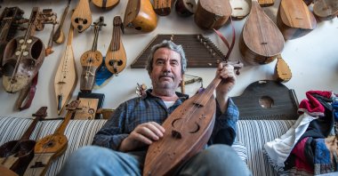 Feridun Obul poses with string instruments he made at his workshop in Sultanahmet Square, Istanbul, Turkey, June 23, 2018. (PHOTO BY MURAT ŞENGÜL)