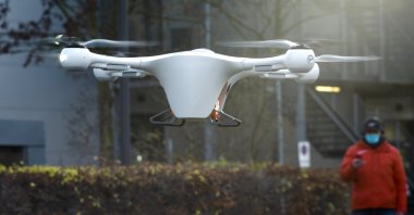 Drone and logistic operator Peter Trempeck monitors the automatic landing of a drone with a case for medical stuff during a presentation for media, near the Labor Berlin laboratory in Berlin, Germany, Nov. 23, 2020. (AP Photo)