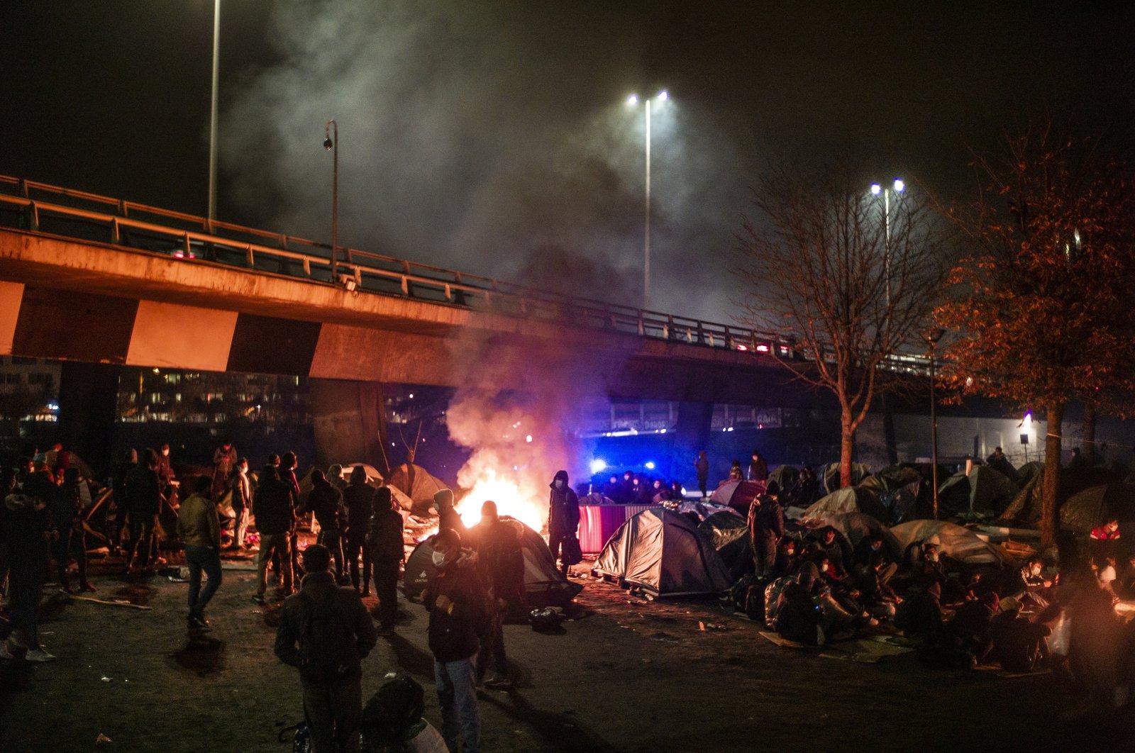 Migrants set fire to their belongings as they wait to be evacuated by French police at a makeshift migrant camp under the A1 freeway, Saint-Denis, north of Paris, France, Nov. 17, 2020. (EPA Photo)