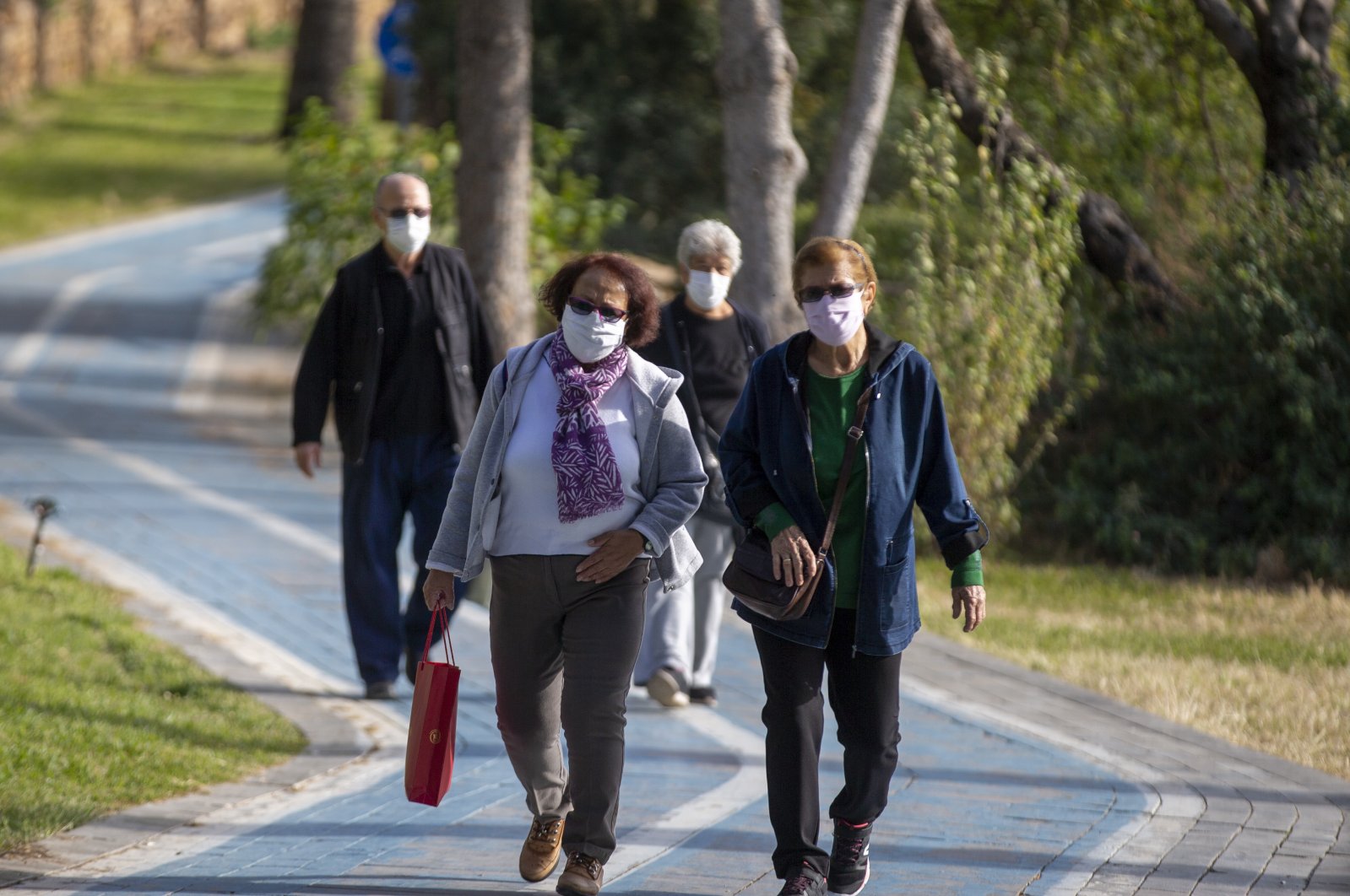 People wearing protective masks walk in a park in Antalya, southern Turkey, Nov. 24, 2020. (AA Photo) 
