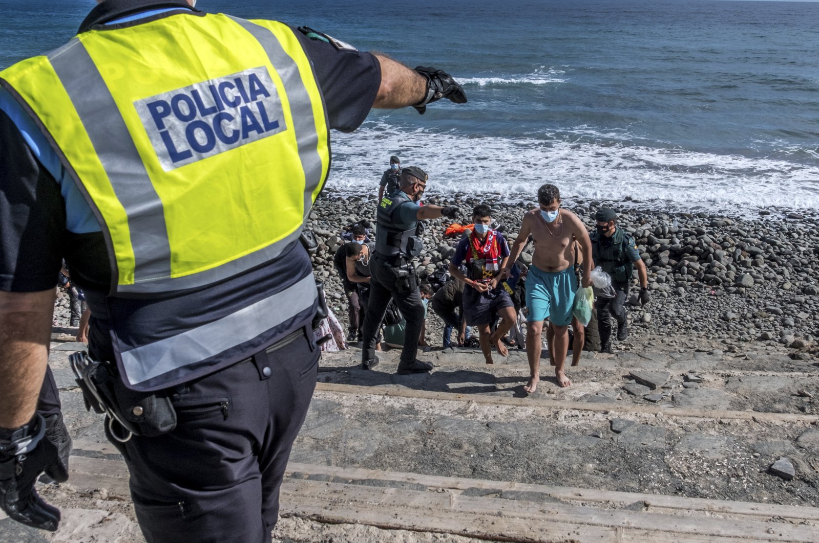 Migrants, most of them from Morocco, are escorted by Spanish police after arriving at the coast of the Canary Islands, Spain, Nov. 23, 2020. (AP Photo)