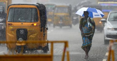 A women walks under an umbrella during heavy rains as cyclone Nivar approaches the eastern Indian coast, in Chennai, India, Nov. 24, 2020. (AFP Photo)
