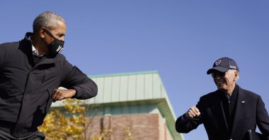 U.S. Democratic presidential candidate Joe Biden and former President Barack Obama greet each other with an air elbow bump at a meeting for the election campaign in Flint, Michigan, U.S., Oct. 31, 2020. (AP Photo)