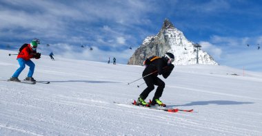 People wearing protective masks ski with the Matterhorn mountain in the background, amid the coronavirus pandemic, at the ski resort in Zermatt, Switzerland, Nov. 21, 2020. (Reuters Photo)
