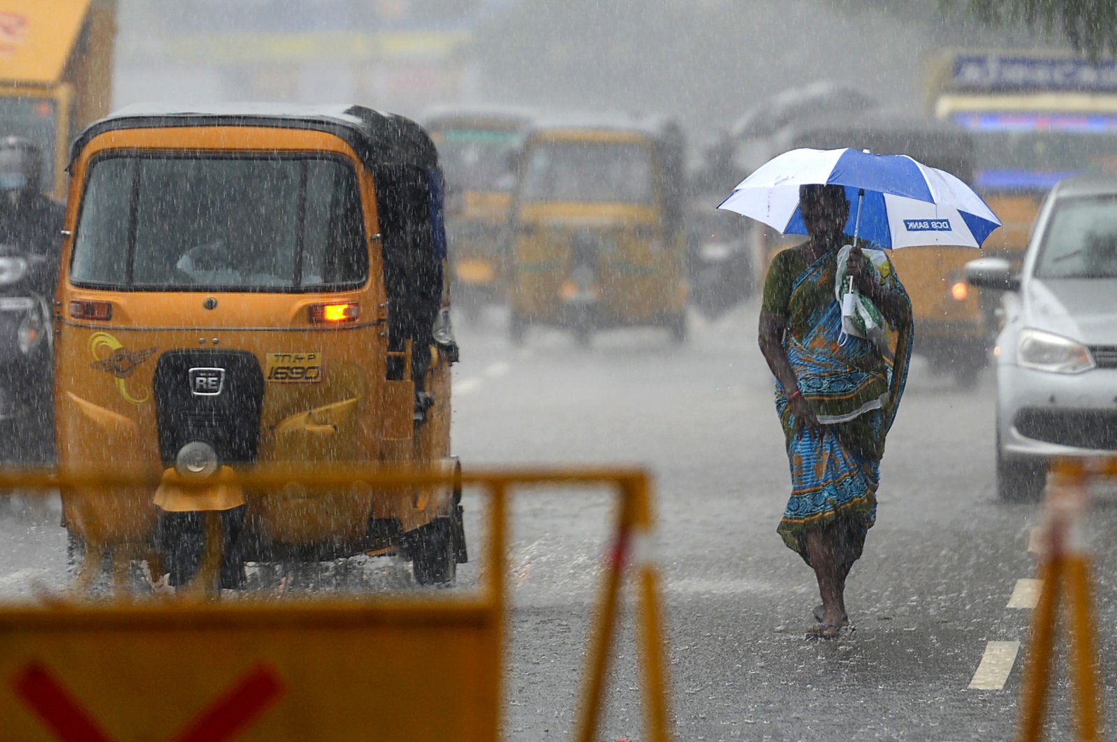 A women walks under an umbrella during heavy rains as cyclone Nivar approaches the eastern Indian coast, in Chennai, India, Nov. 24, 2020. (AFP Photo)