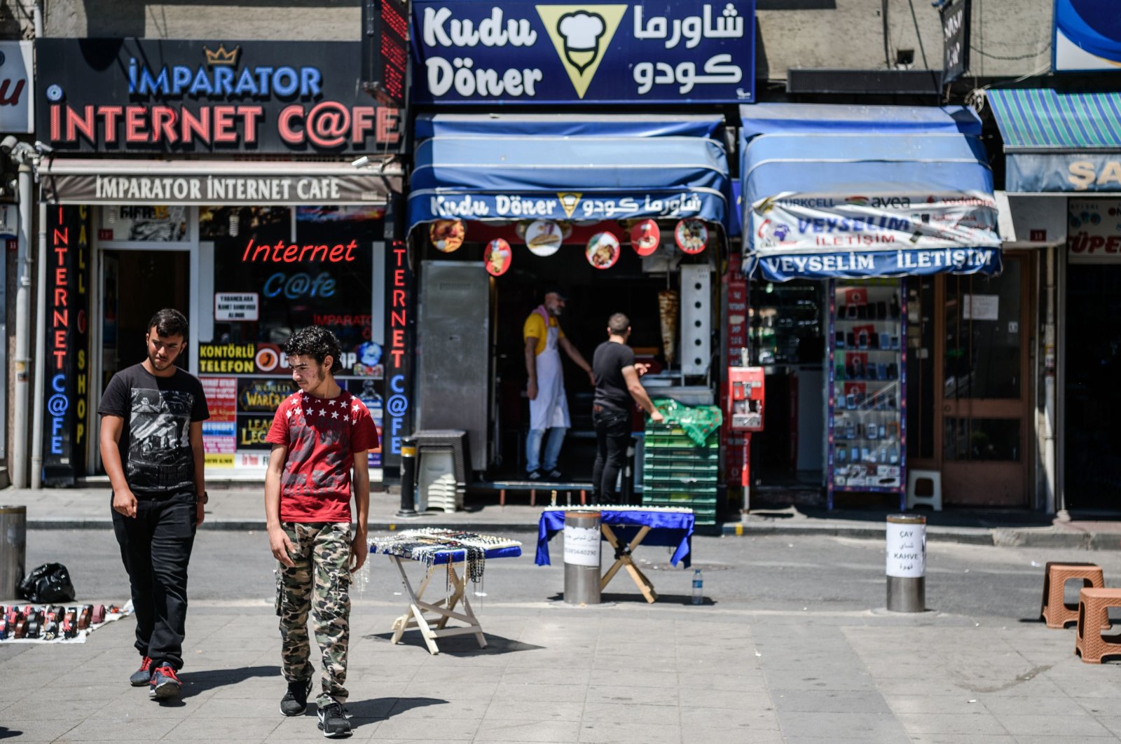 Syrian men walk pass a Syrian fast food restaurant in the Fatih district of Istanbul, Turkey, July 4, 2016. (AFP Photo)