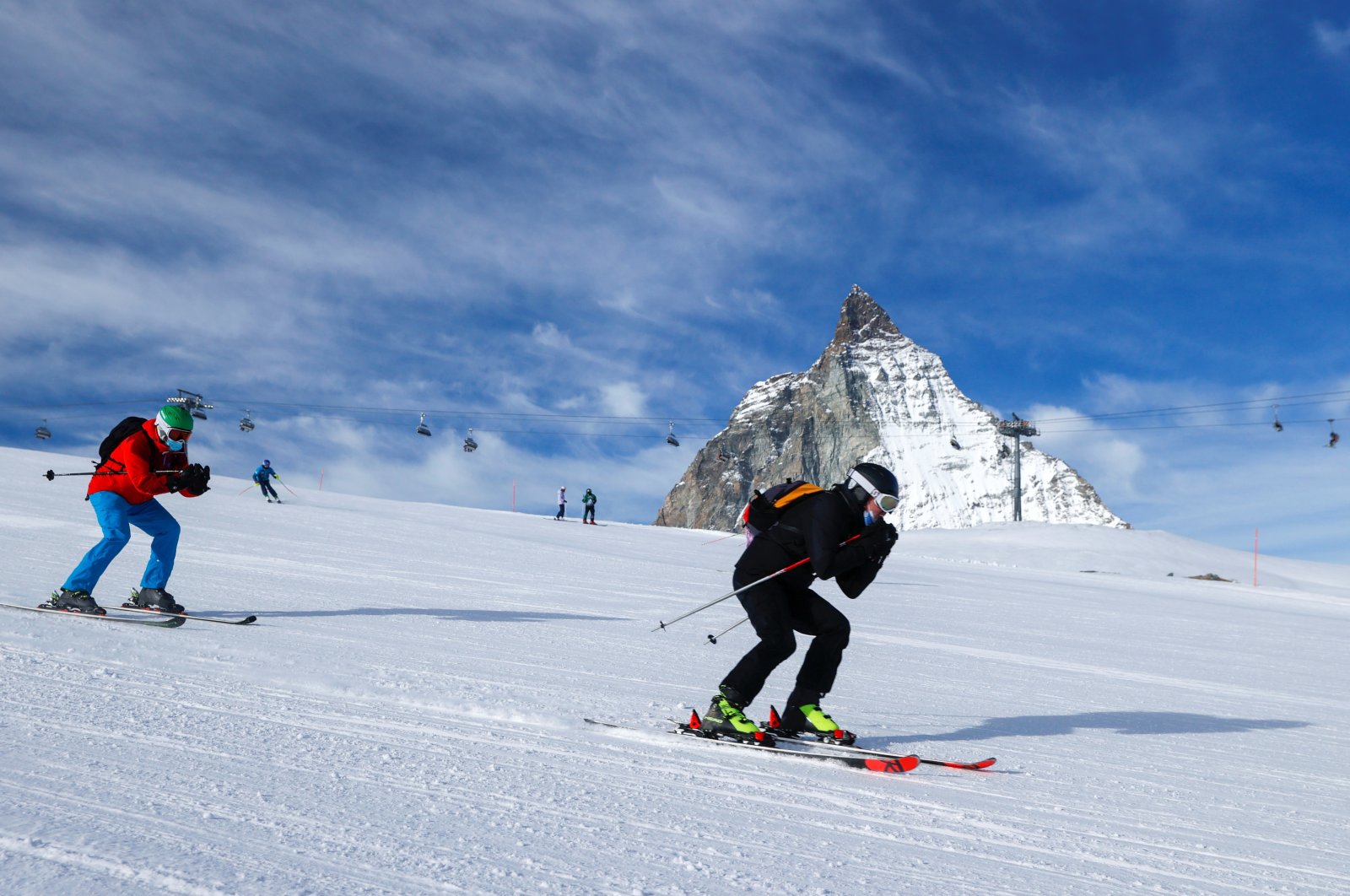 People wearing protective masks ski with the Matterhorn mountain in the background, amid the coronavirus pandemic, at the ski resort in Zermatt, Switzerland, Nov. 21, 2020. (Reuters Photo)