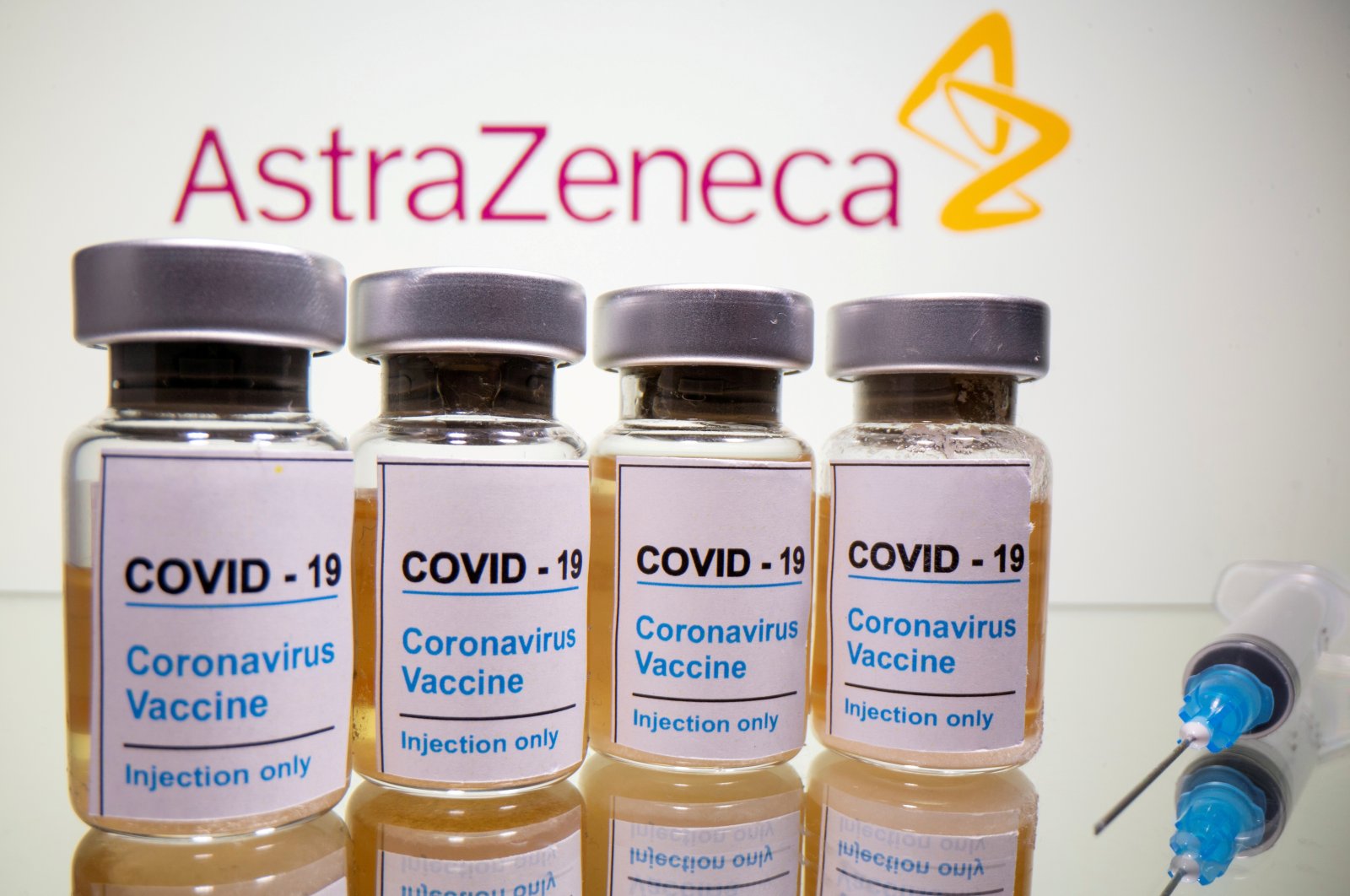 Vials with a sticker reading, "COVID-19/Coronavirus vaccine/Injection only" and a medical syringe are seen in front of a displayed AstraZeneca logo in this illustration taken Oct. 31, 2020. (Reuters Photo)