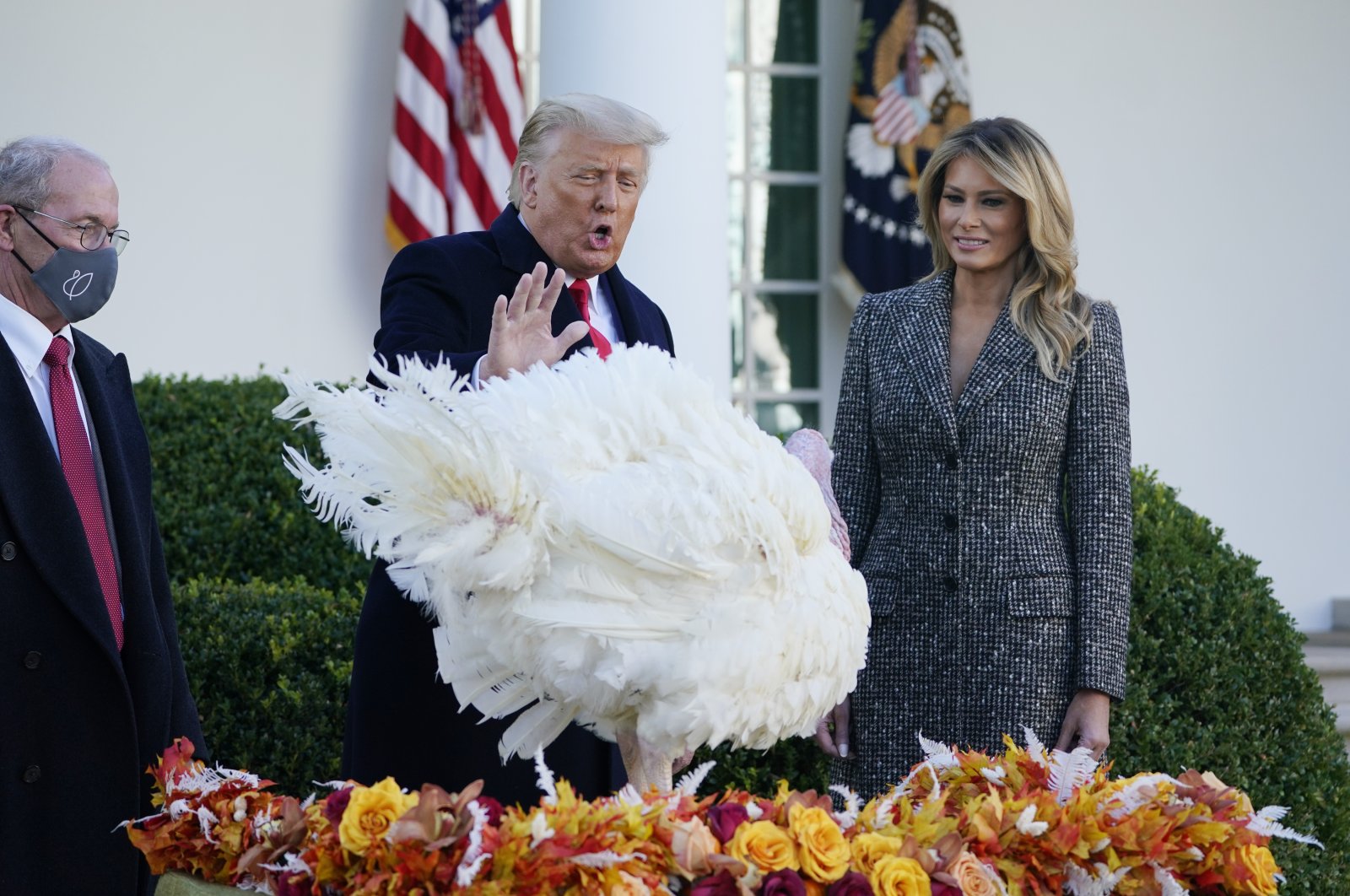 President Donald Trump (C) pardons Corn, the national Thanksgiving turkey, as National Turkey Federation Chairman Ron Kardel (L) of Walcott, Iowa, and first lady Melania Trump (R) look on in the Rose Garden of the White House in Washington, D.C., Nov. 24, 2020. (AP Photo)