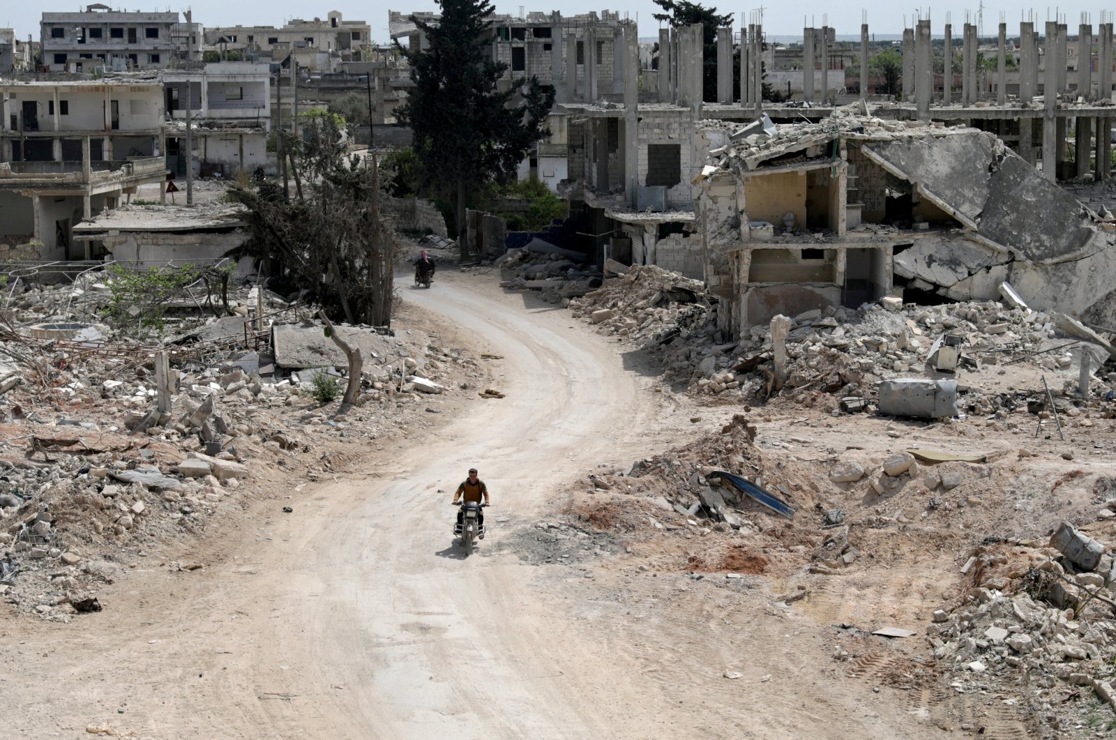 A man rides a motorbike past damaged buildings in the opposition-held town of Nairab, in the Idlib region of Syria, April 17, 2020. (Reuters Photo)