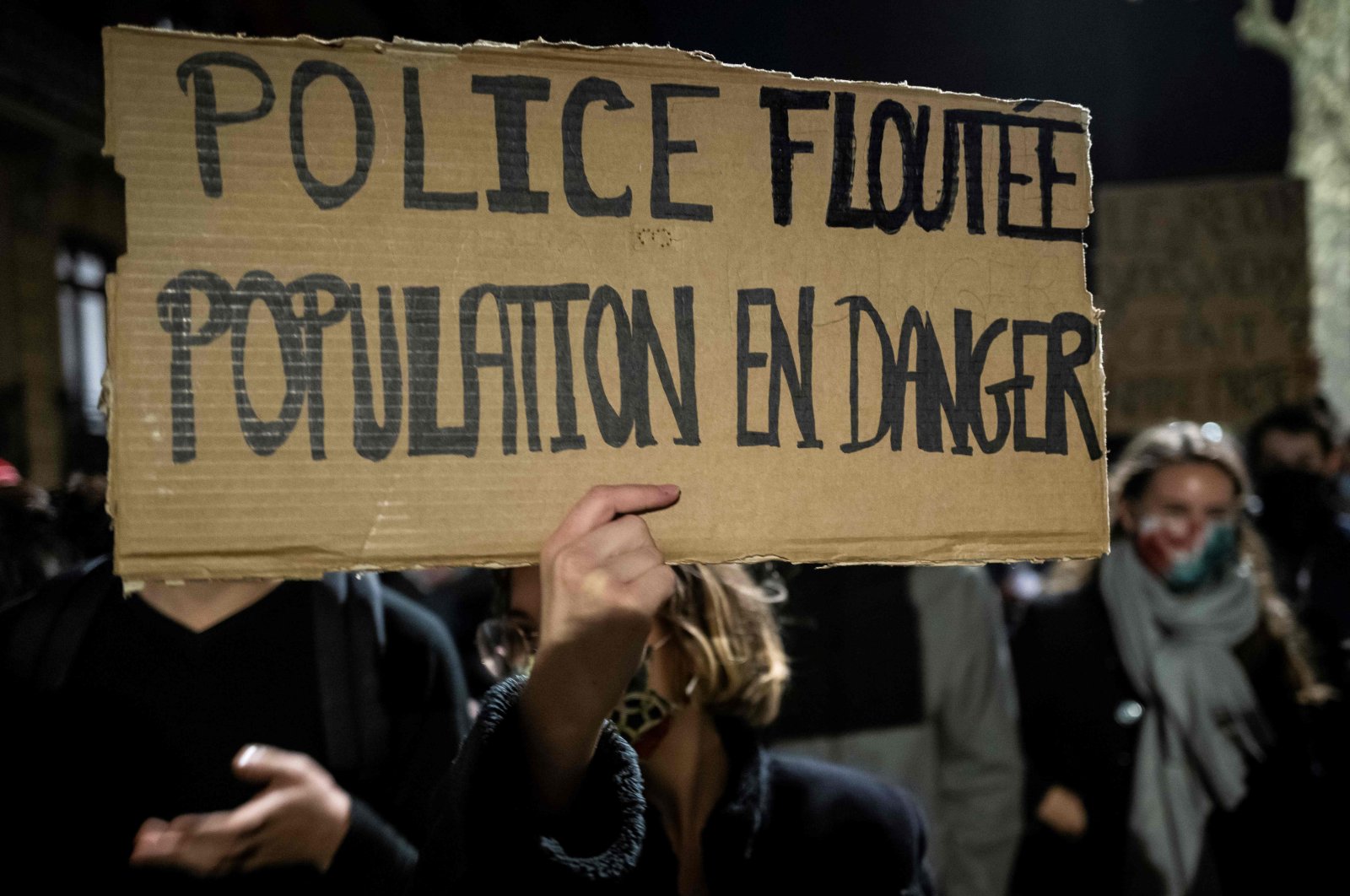 A woman holds a placard reading "Police blurred population in danger" as she takes part in a demonstration, Toulouse, southern France, Nov. 26, 2020. (AFP Photo)