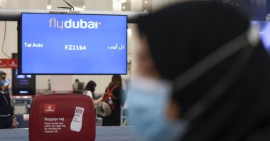 A woman walks past luggage pick-up for arrivals from Tel Aviv to the Dubai airport in the United Arab Emirates, on November 26, 2020, on the first scheduled commercial flight operated by budget airline flydubai, following the normalisation of ties between the UAE and Israel. (AFP Photo)