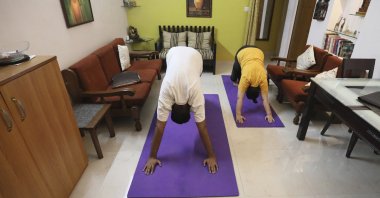 A couple practices yoga in their home to mark International Yoga Day through an online class in New Delhi, India, June 21, 2020. (AP Photo)