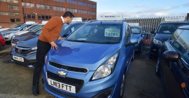 Ameen Sultani, general manager of used car dealer Nawaie Motoring Ltd., looks inside a car as he shows some of the older, cheaper vehicles that have been popular with customers eager to avoid public transport during the coronavirus pandemic, in Hayes, Britain, Nov. 12, 2020. (Reuters Photo)