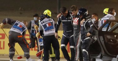 Stewards and medics attend to Romain Grosjean after the crash, in Sakhir, Bahrain, Nov. 29, 2020. (AFP Photo) 
