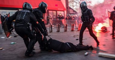 Police officers drag a man on the ground during protests, Paris, Nov. 28, 2020. (AFP Photo)