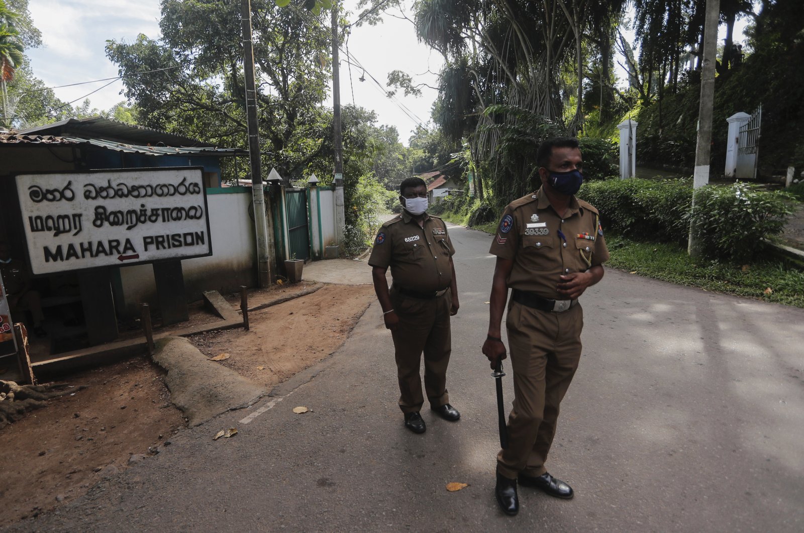 Sri Lankan police officers stand guard at the entrance to the Mahara prison complex following overnight unrest in Mahara, the outskirts of Colombo, Sri Lanka, Nov. 30, 2020. (AP Photo)