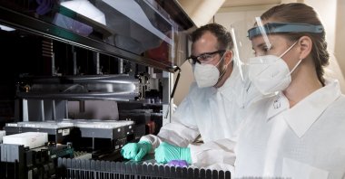 A senior proteomics scientist and a research associate work in a lab that analyzes blood samples at the company's facility in the Center for Emerging Technologies in St. Louis, July 22, 2020. (C2N Diagnostics via AP)