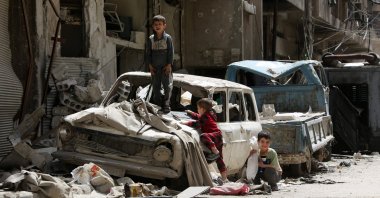 Syrian boys play on a destroyed car in the former opposition-held town of Douma on the outskirts of Damascus, Syria, April 19, 2018. (AFP Photo)

