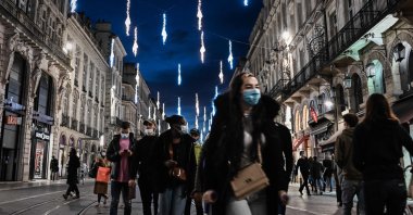 Pedestrians walk under Christmas decorations in a shopping street in Bordeaux, southwestern France, Nov. 28, 2020. (AFP Photo)