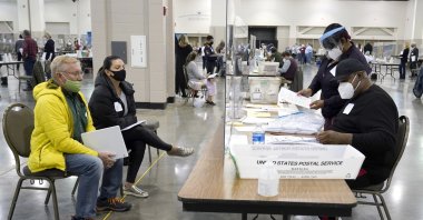 Election workers, right, verify ballots as recount observers, left, watch during a Milwaukee hand recount of presidential votes at the Wisconsin Center in Milwaukee, U.S., Nov. 20, 2020. (AP Photo)