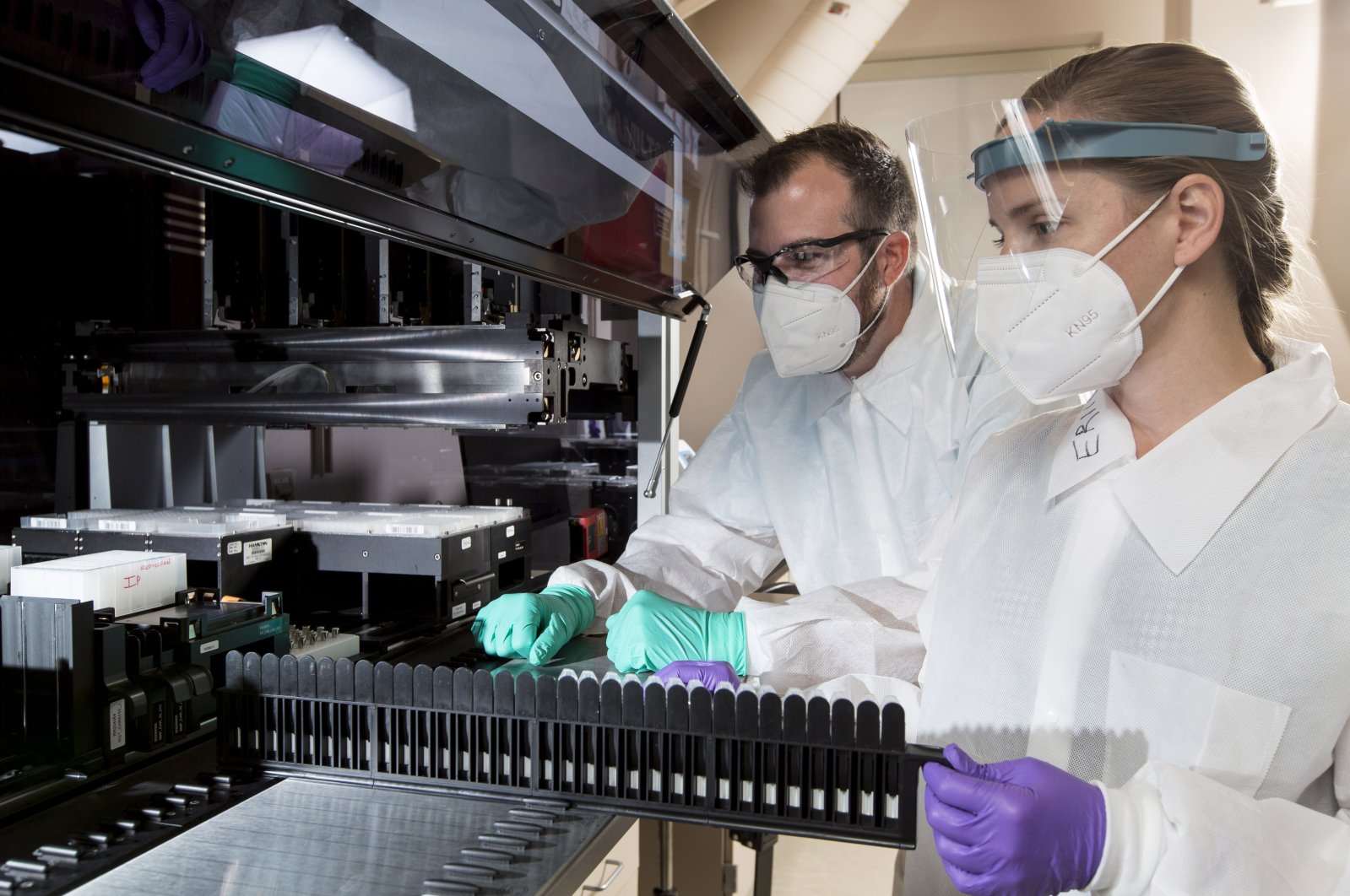 A senior proteomics scientist and a research associate work in a lab that analyzes blood samples at the company's facility in the Center for Emerging Technologies in St. Louis, July 22, 2020. (C2N Diagnostics via AP)