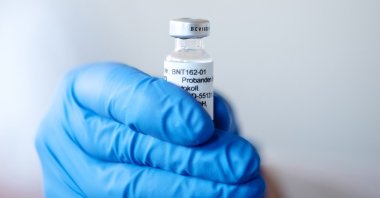 A hand holds an ampoule with BNT162b2, the mRNA-based vaccine candidate against COVID-19, in Mainz, Germany, in this undated photo. (BioNTech handout via EPA)