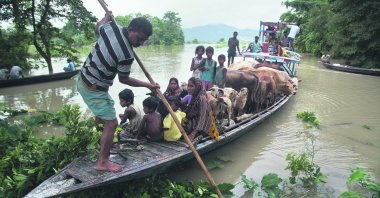A boat carries flood-affected villagers and cattle to a highland in the Katahguri village along the river Brahmaputra, east of Gauhati, India, July 14, 2019. (AP Photo)