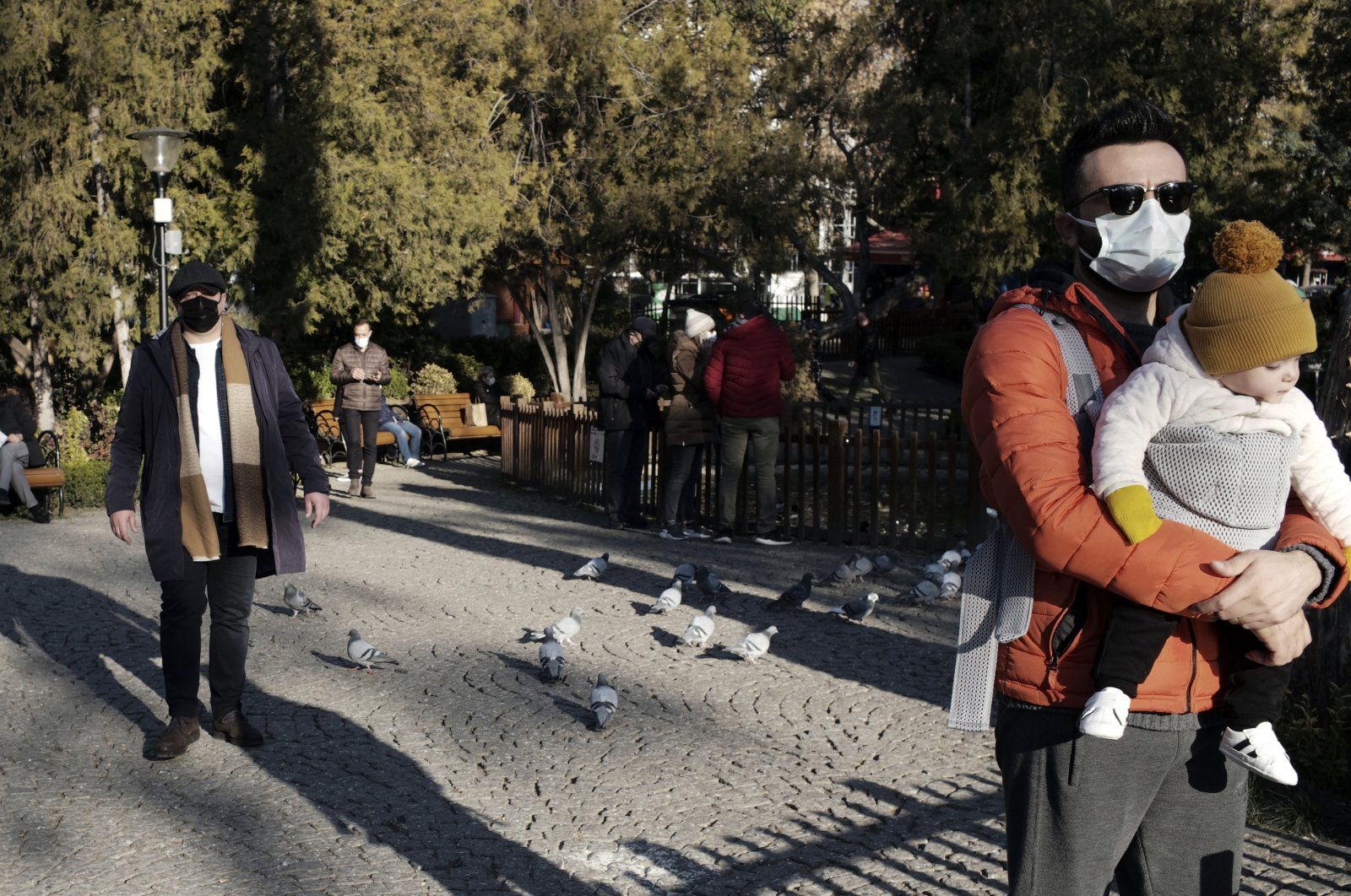 People wearing masks to help protect against the spread of coronavirus, visit a public garden in the capital Ankara, Turkey, Nov. 27, 2020. (AP Photo)