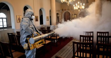 A worker uses a thermal fogger to disinfect a church in Thessaloniki, Greece, March 12, 2020. (AFP Photo)